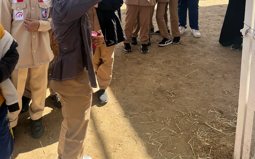 AFS pupils in uniform gathered on the sandy ground at the equestrian centre